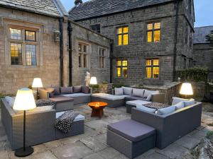 a patio with couches and tables in front of a building at Riber Hall in Matlock Bank