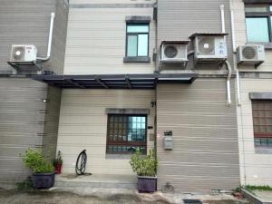 a house with air conditioners on the side of it at 湖下海景民宿 in Jinning
