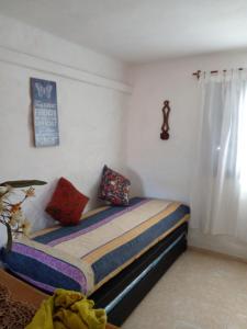 una camera da letto con un letto con cuscini colorati di Cabañas La Escondida Casa De Campo 2 a San Antonio de Arredondo Altre 21 foto