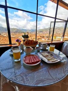 a table with food and drinks on a table with a view at Hostal Tu Hogar in Cusco