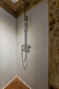 a shower in a bathroom with white tiles at ir-Remissa - Historic Home in Victoria Old Town in Victoria +20 photos