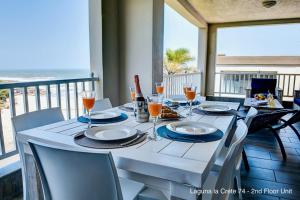 - une table avec des assiettes et des verres à vin sur un balcon dans l'établissement Laguna la Crete 74 & 90, à Margate