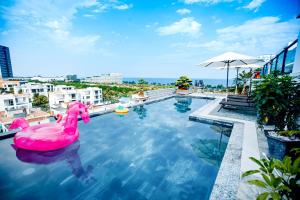 a pool with a pink float in the water at Khách sạn Galvin FLC Sầm Sơn in Sầm Sơn