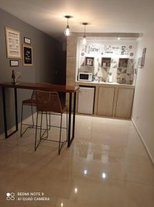 eine Küche mit einem Tisch, Stühlen und einer Theke in der Unterkunft Mágnum Apartments Studio in Mendoza