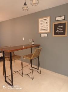 a dining room table with two chairs and a chalkboard at Mágnum Apartments Studio in Mendoza