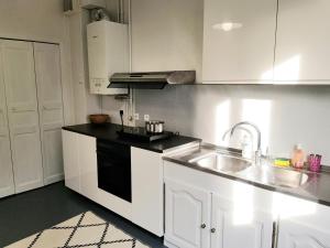 - une cuisine avec des placards blancs et un évier dans l'établissement Suite 53m2 - Appartement privé - Grand Paris, à Noisy-le-Sec