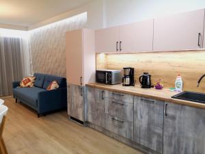 a kitchen with a couch and a counter with a microwave at Apartament Pod Papugami Karpatia Resort in Karpacz