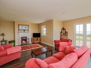 a living room with red furniture and a fireplace at Josie's House in Fethard on Sea