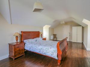 a bedroom with a bed and a wooden dresser and a table at Josie's House in Fethard on Sea