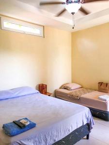 1 dormitorio con 2 camas y ventilador de techo en Casa Inti Guesthouse & Lodge, en Managua