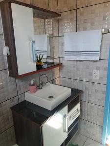 a bathroom with a sink and a mirror at Morada família feliz - Praia Grande SC in Praia Grande +7 photos