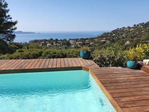 a swimming pool on a deck with a wooden deck at Pretty house with sea view on the Hy res in Hyères