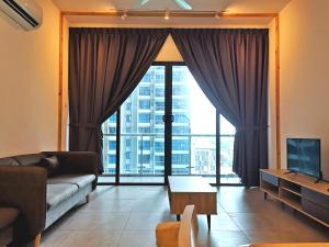 a living room with a couch and a large window at Golden House-Atlantis Residence in Malacca