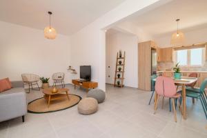 ein Wohnzimmer mit einem Sofa, einem Tisch und Stühlen in der Unterkunft Casa il Fiume in Alykes