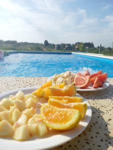 dos platos de fruta en una mesa cerca de una piscina en Los colibries, en San Pedro