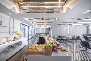 a dining room with a long table with food on it at Atour Light Hotel Chengdu Wenjiang in Wenjiang