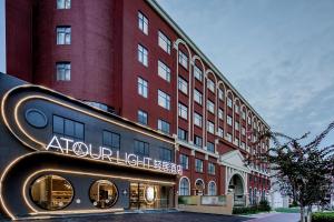 a hotel with a sign in front of a building at Atour Light Hotel Chengdu Wenjiang in Wenjiang