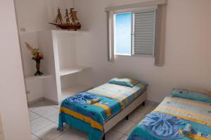 a bedroom with two twin beds and a window at Hotel Marina Clube de Pesca in Cananéia