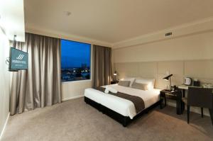 a hotel room with a large bed and a large window at Woodroffe Hotel in Gold Coast