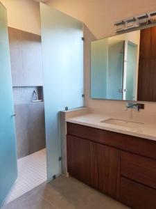 Un baño con lavabo, espejo y ducha. en Luxury Villa Cascada- infinity oceanview pool and elevator, en Isla Mujeres 28 fotos más