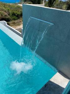 a water fall in a swimming pool at Luxury Villa Cascada- infinity oceanview pool and elevator in Isla Mujeres