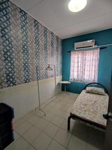 Habitación hospitalaria con cama y ventana en Rumah teres 2 tingkat & 3 bilik, en Pasir Gudang