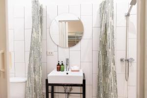 a white bathroom with a sink and a mirror at Oon Poshtel x Cafe in Chiang Mai