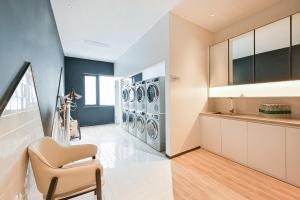 a laundry room with a row of washers and dryers at Atour Hotel Beijing Hepingli UIBE in Beijing