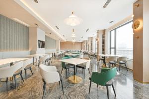 a dining room with tables and chairs and a large window at Atour Hotel Beijing Hepingli UIBE in Beijing