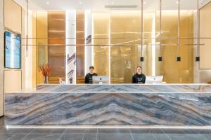 a lobby with two men sitting at their laptops at Atour Hotel Shangxing Lu Xun s Hometown in Shaoxing