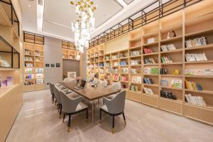 Hai'anにあるAtour Hotel Hai an City Governmentのダイニングルーム(テーブル、椅子、本棚付)