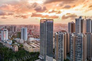 een skyline van de stad met een hoge wolkenkrabber bij Atour Hotel Nanning North Lake Railway Station in Nanning