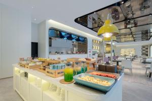 a restaurant with a buffet of food on a counter at Atour Light Hotel Qingdao International Convention Center in Qingdao