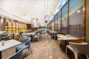 a dining room with tables and chairs in a restaurant at Atour Hotel Kunming International Trade Center in Kunming