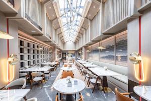 a restaurant with tables and chairs and a ceiling at Atour Hotel Yuzhong Yuci Incity in Jinzhong