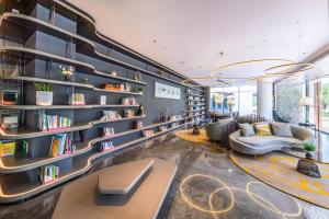 a library with bookshelves and couches in a room at Atour Light Hotel Jinan International Covention Centre in Jinan
