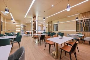 uma sala de jantar com mesas e cadeiras num restaurante em Atour Hotel Ezhou City Government em Ezhou