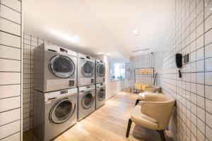 a laundry room with four washer and dryer machines at Atour Hotel Nanchang Red Valley Beach Causeway Bay in Nanchang