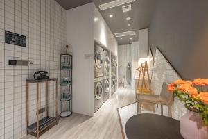 a laundry room with washing machines and a vase of flowers at Atour Hotel Kunshan Baoyu Plaza North Changjiang Road in Kunshan