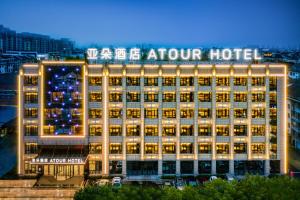 un grand bâtiment avec un panneau en haut dans l'établissement Atour Hotel Huzhou Nanxun Ancient Town, à Huzhou