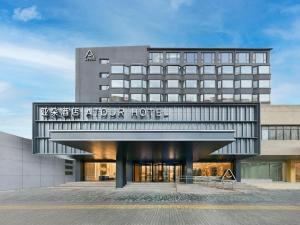 a hotel front view of a four story hotel at Atour Hotel Beijing Hepingli UIBE in Beijing