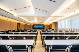 una sala conferenze vuota con tavoli e sedie di Atour S Hotel Shenzhen Longgang Zhonghaixing a Longgang