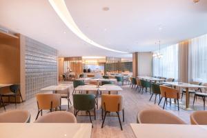 uma sala de jantar com mesas e cadeiras em Atour Hotel Wuhan International Expo Center em Wuhan