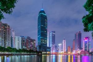 eine Skyline der Stadt in der Nacht mit einem hohen Gebäude in der Unterkunft Atour Hotel Wuhan Hankou Financial Center in Wuhan