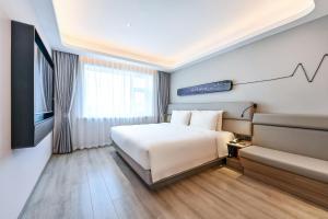 a hotel room with a bed and a couch at Atour Light Hotel Jilin Xiamen Street in Jilin