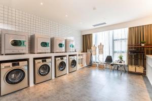 a laundry room with four washer and dryer machines at Atour Changsha Xingsha in Changsha