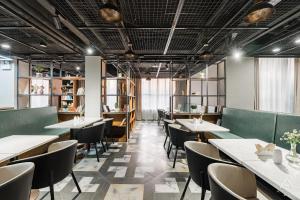 a restaurant with tables and chairs and windows at Atour Light Hotel Nantong West Youth Road in Nantong