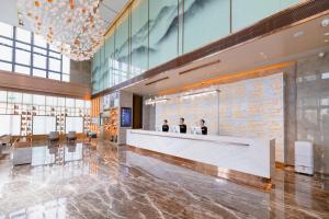 a lobby with people sitting at a reception desk at Atour Hotel Huizhou Zhongkai Tianyi in Huizhou