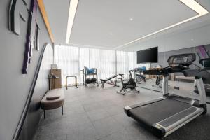 een kamer met een fitnessruimte met een loopband en stoelen bij Atour Hotel Nanning Wuxiang Headquarter Base in Nanning