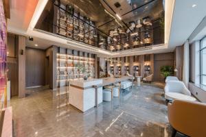 a bar in a hotel lobby with white chairs at Atour Hotel Jiaxing Pinghu in Pinghu